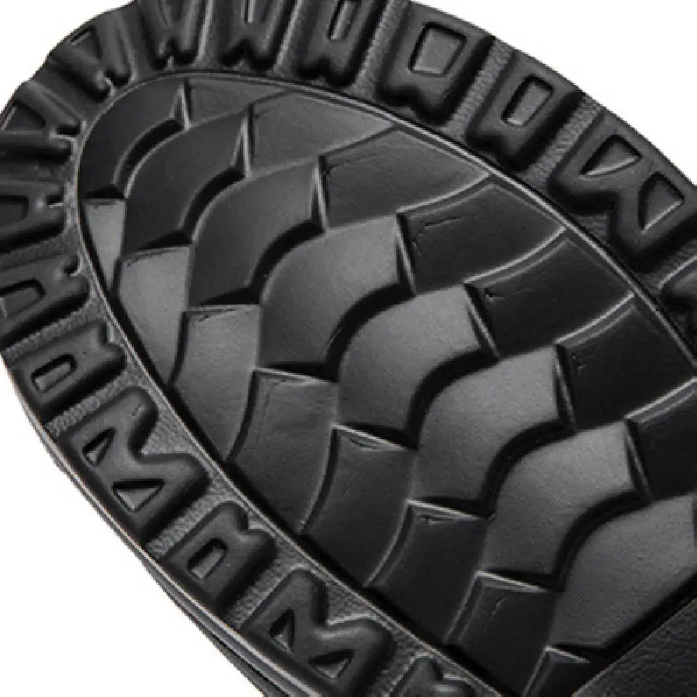 Semelle en caoutchouc noire à motif de sculpture ondulé texturé et lettrage en relief sur des chaussures en cuir à talon compensé en forme de coin