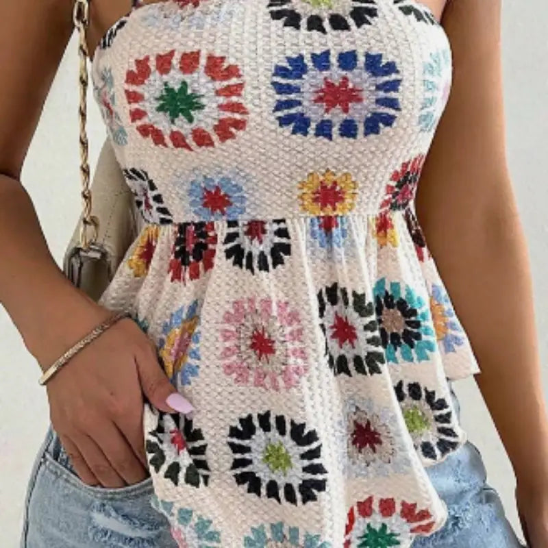 A colorful crocheted floral peplum camisole top featuring a vibrant pattern of red blue green and yellow circular motifs on an off-white background.