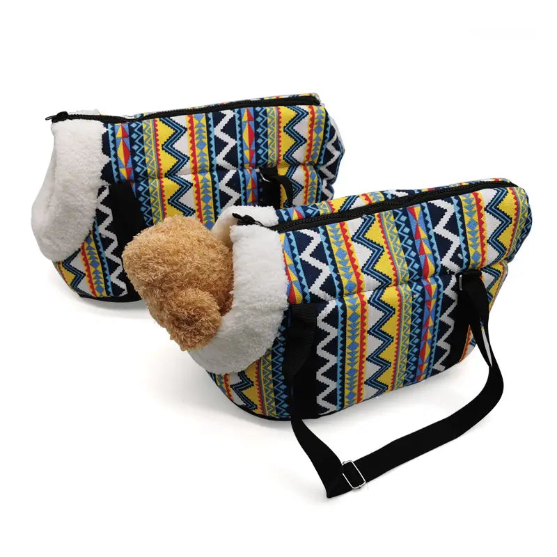 Colorful geometric-patterned warm pet carrier made of canvas with plush white fleece lining and black straps for travel use.