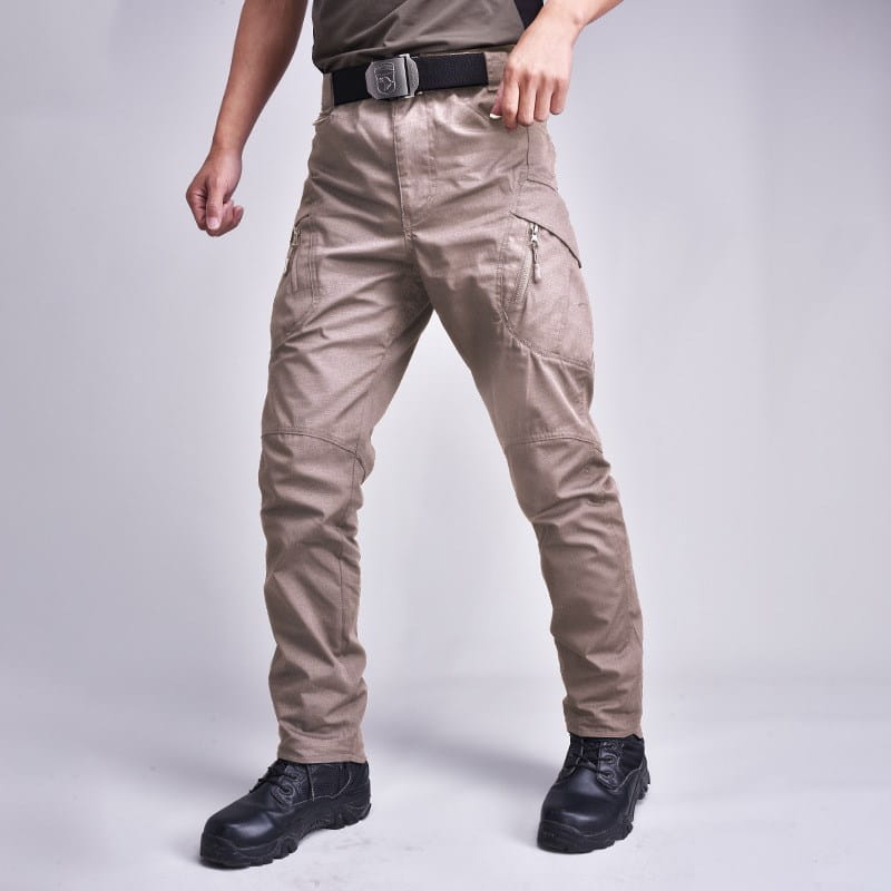 Tan tactical military combat pants for men featuring multiple zippered pockets and reinforced stitching for durability and functionality.