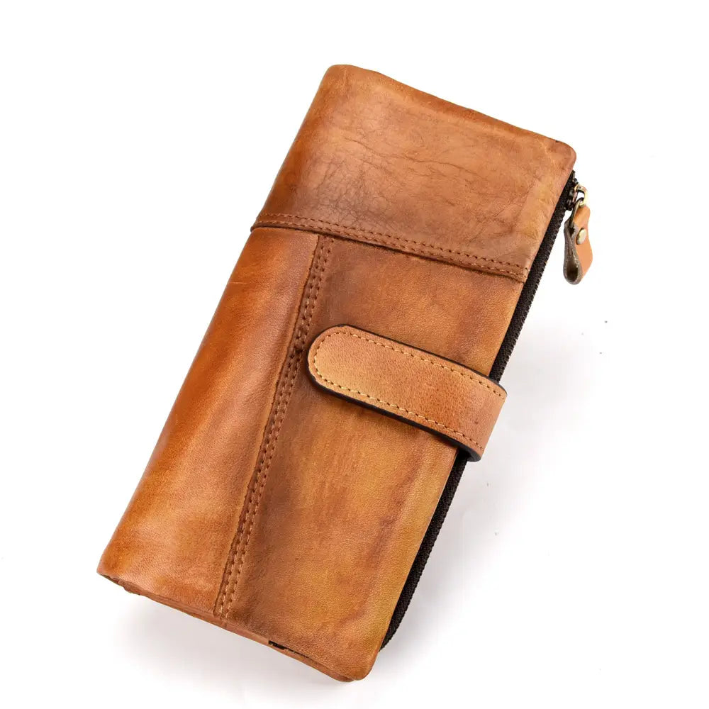 A tan distressed leather long wallet with vintage stitching zipper closure and flap strap.
