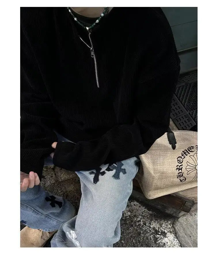 Sudadera tipo jersey de pana negra aterciopelada acanalada para hombre con media cremallera, con cremallera plateada y bordado cruzado negro en el frente.