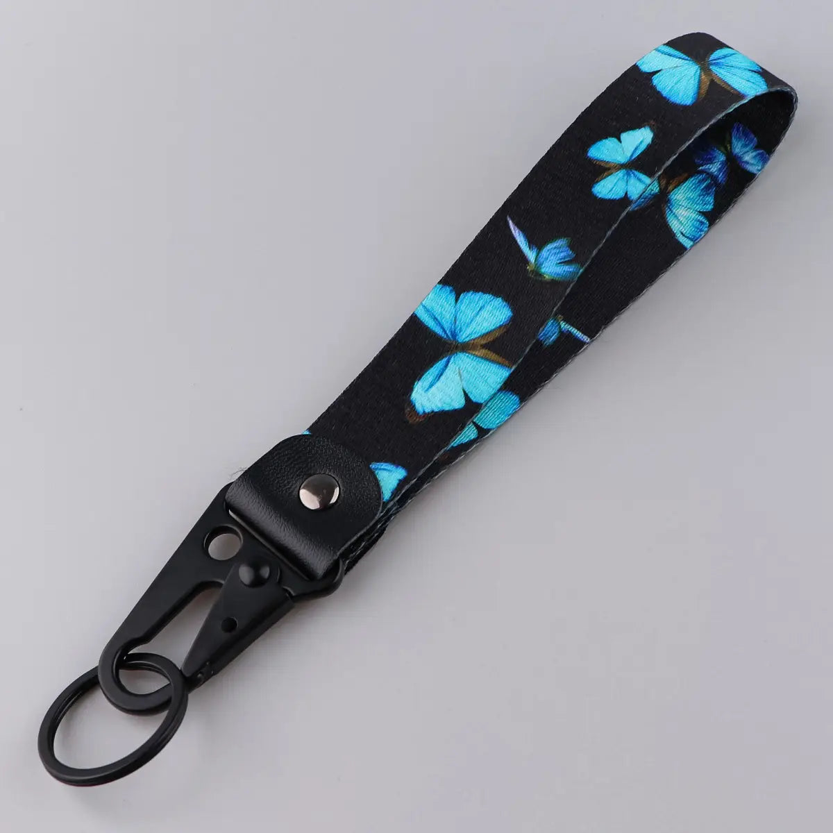 Black wrist strap keychain with vibrant blue butterfly pattern and black metal carabiner clip for secure attachment model Tk57.