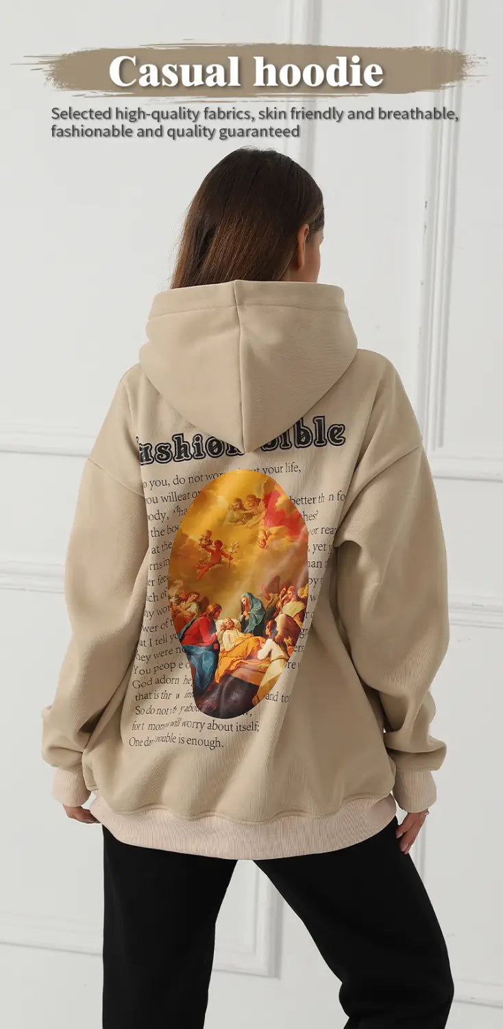 The back side of a beige women’s oversized casual hoodie features a vibrant detailed graphic print with classical artwork and text.