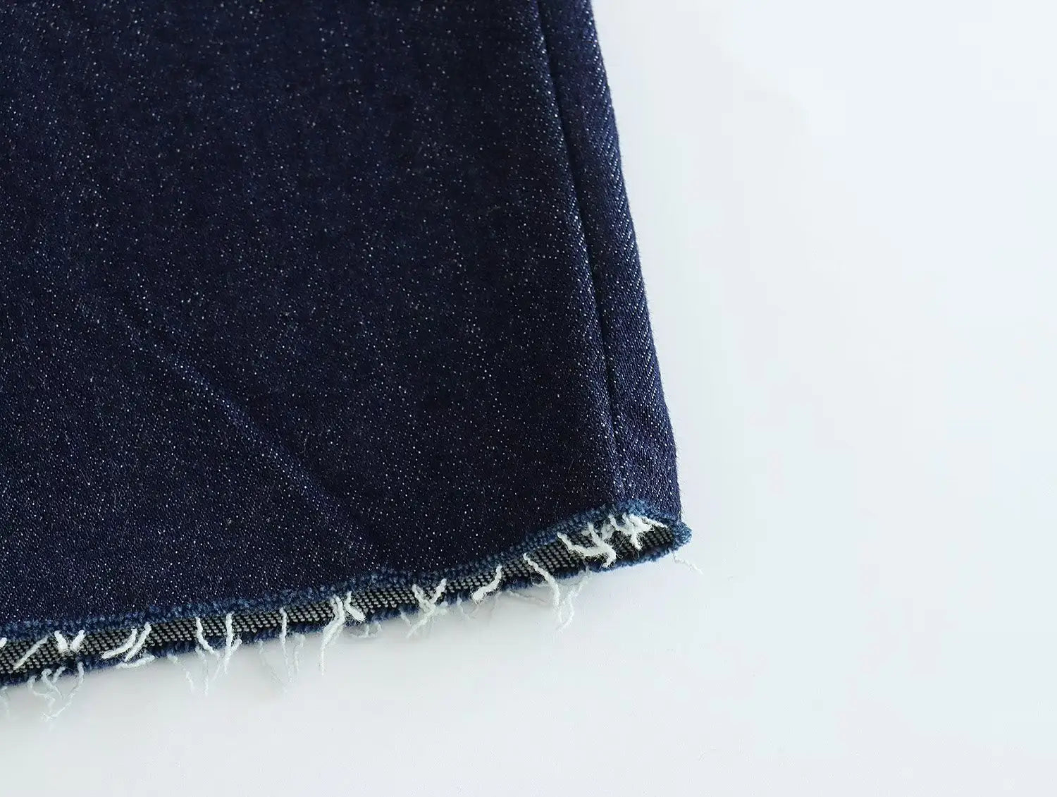 dark blue denim fabric with a frayed edge and visible stitching featured on a high neck navy velvet zip front maxi dress.