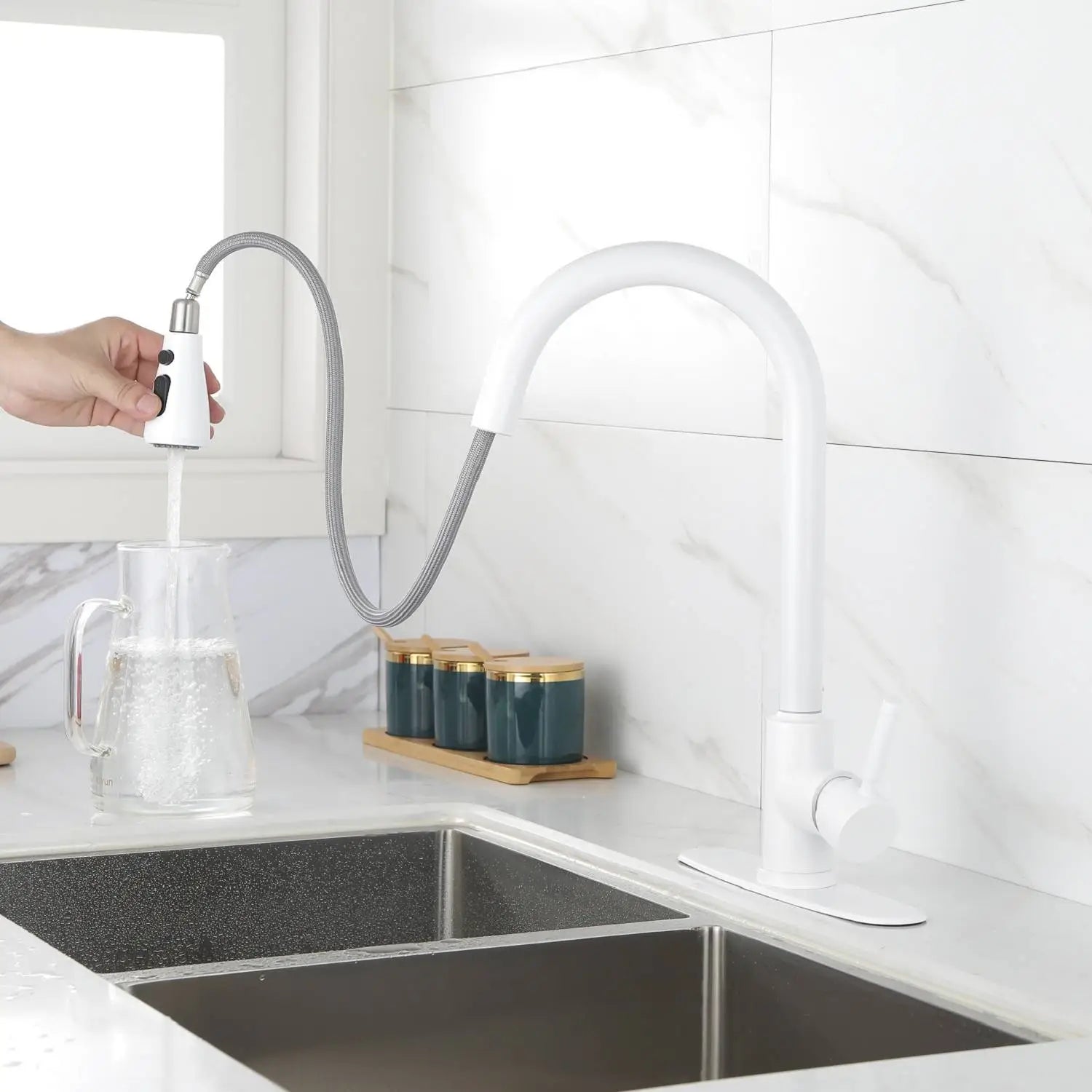 Robinet de cuisine blanc mat avec douchette escamotable, comprenant un flexible métallique et une tête de pulvérisation extractible.