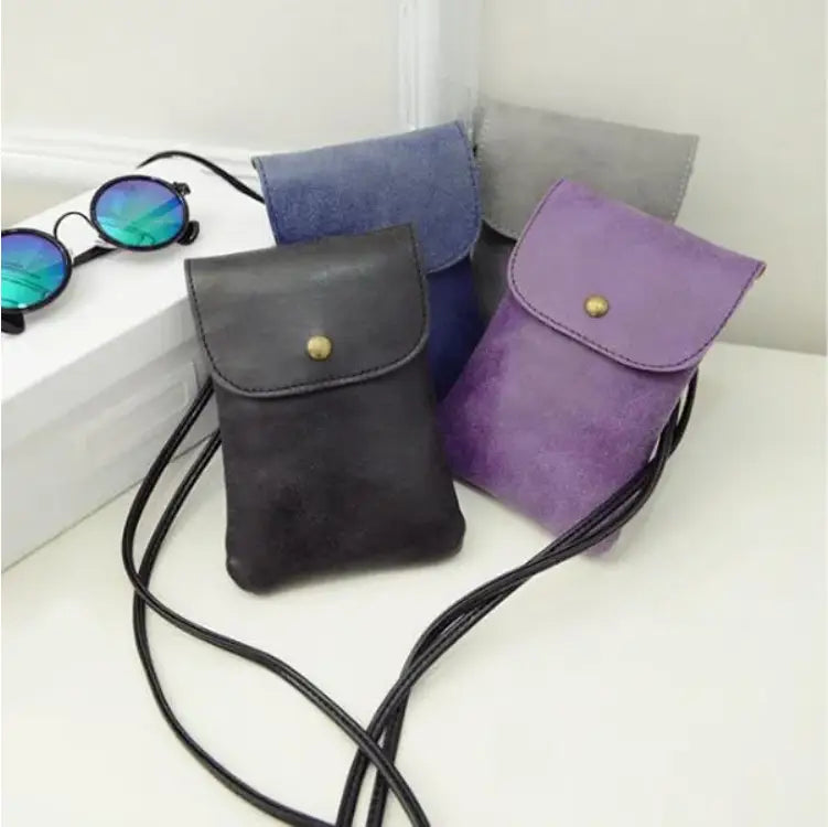 a collection of old worldly charm matte suede vegan leather crossbody phone bags in black purple and blue with gold-tone snap closures