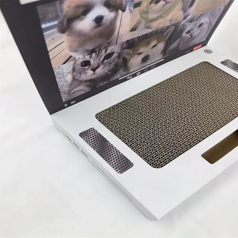 Weiße, laptopförmige Katzenkratze mit einem Bildschirm, der niedliche Haustiere zeigt, und einer strukturierten Pappkarton-Kratzoberfläche, gestaltet als Pappkarton-Notizblock-Spielzeug.