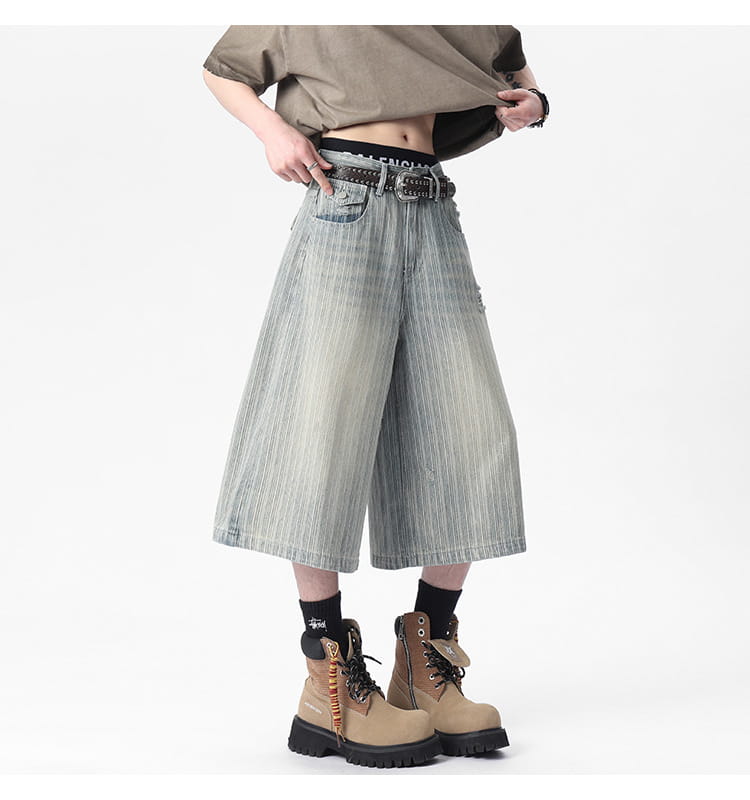striped denim capri shorts featuring wide-leg denim pants in a faded light blue wash with vertical stripes and distressed details