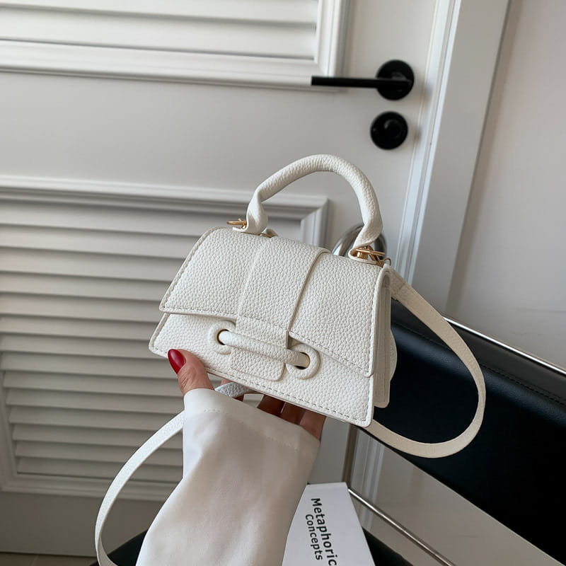 Weiße, strukturierte Mini-Handtasche aus Lederoptik mit goldfarbenen Beschlägen und oberem Tragegriff in einem Design einer Ketten-Umhängetasche Mini aus Kunstleder.