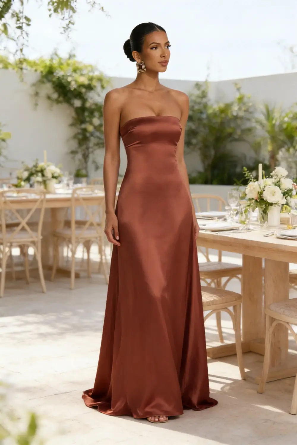 Vestido de noche sin tirantes de satén elegante en color óxido intenso, con una silueta lisa y fluida y escote drapeado.