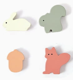 Gommes en bois aux couleurs pastel, en formes d’animaux (lapin, écureuil, gland et renard), présentées avec le jouet pour cube d’activités en bois à 5 en 1 en forme de champignon.