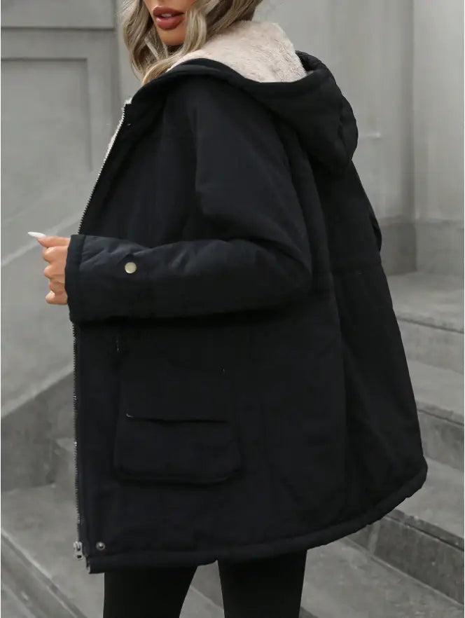 Black sherling lined hooded zip up parka with plush white shearling lined hood and front pockets.