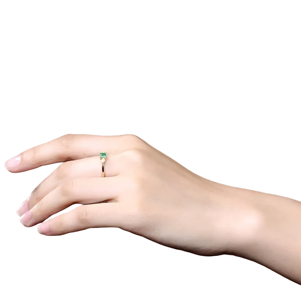 18k gold emerald diamond engagement ring with a delicate gold band and a rectangular emerald stone in a minimalist design