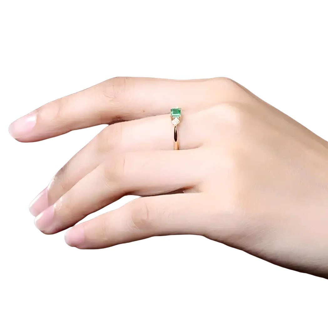 18k gold emerald diamond engagement ring with a delicate rose gold band and rectangular emerald stone in minimalist design