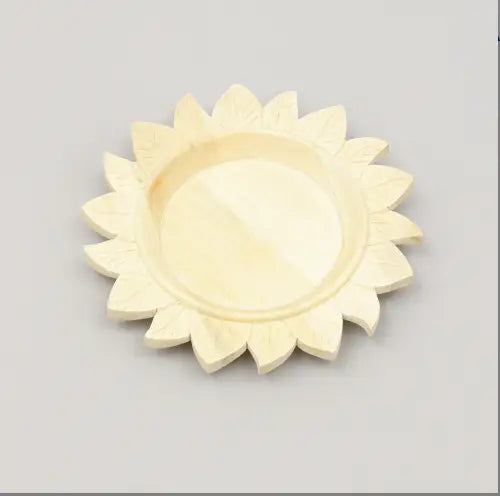 Assiette plate en bois couleur crème, finement sculptée en forme de lotus, avec une finition lisse légèrement brillante, provenant d’un ensemble de table rustique fait à la main.