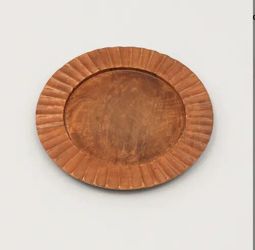 Assiette plate ovale en bois couleur cuivre, bord cannelé à relief et surface centrale lisse, provenant d’un ensemble de table rustique fait à la main.