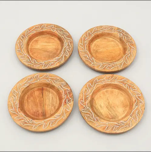 Lot de quatre dessous-de-plat en bois brun clair, avec des motifs de feuilles sculptées tout autour du bord, provenant de l’ensemble de table rustique en assiettes plates en bois fait à la main.