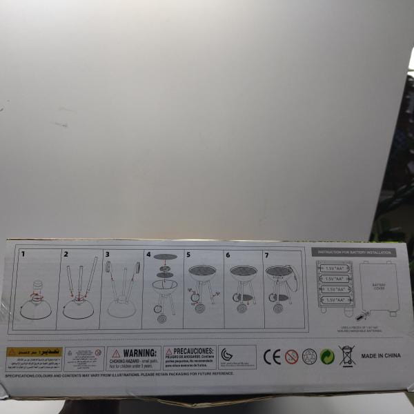the back side of the box for a smoking barbecue grill toy with light and sound ic featuring a 12v battery-powered decorative lighting system with illustrated assembly instructions and safety warnings.