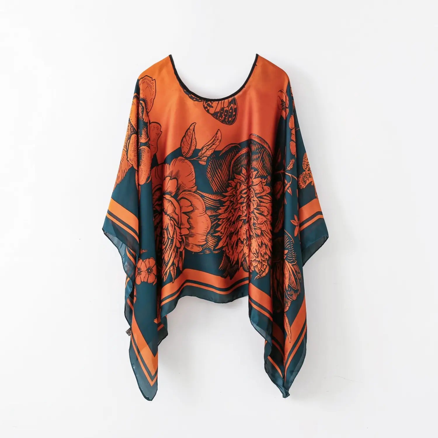 a flowing printed silk patterned pullover shawl cape outerwear featuring an orange and teal floral print with a black-trimmed neckline