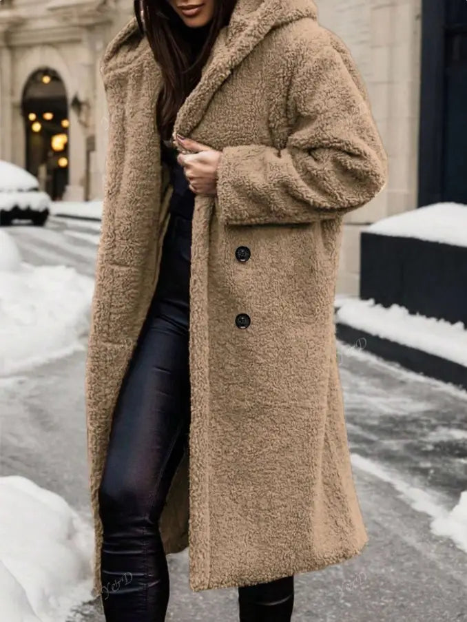 A cozy tan faux fur teddy bear coat with a hood and black buttons designed as a long outerwear piece.