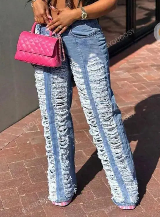 Eine leuchtend pinkfarbene, wattierte Ledertasche mit Kettenhenkel, dargestellt neben verzweifelten Jeans mit weitem Bein und zerrissenen Partien für Damen.