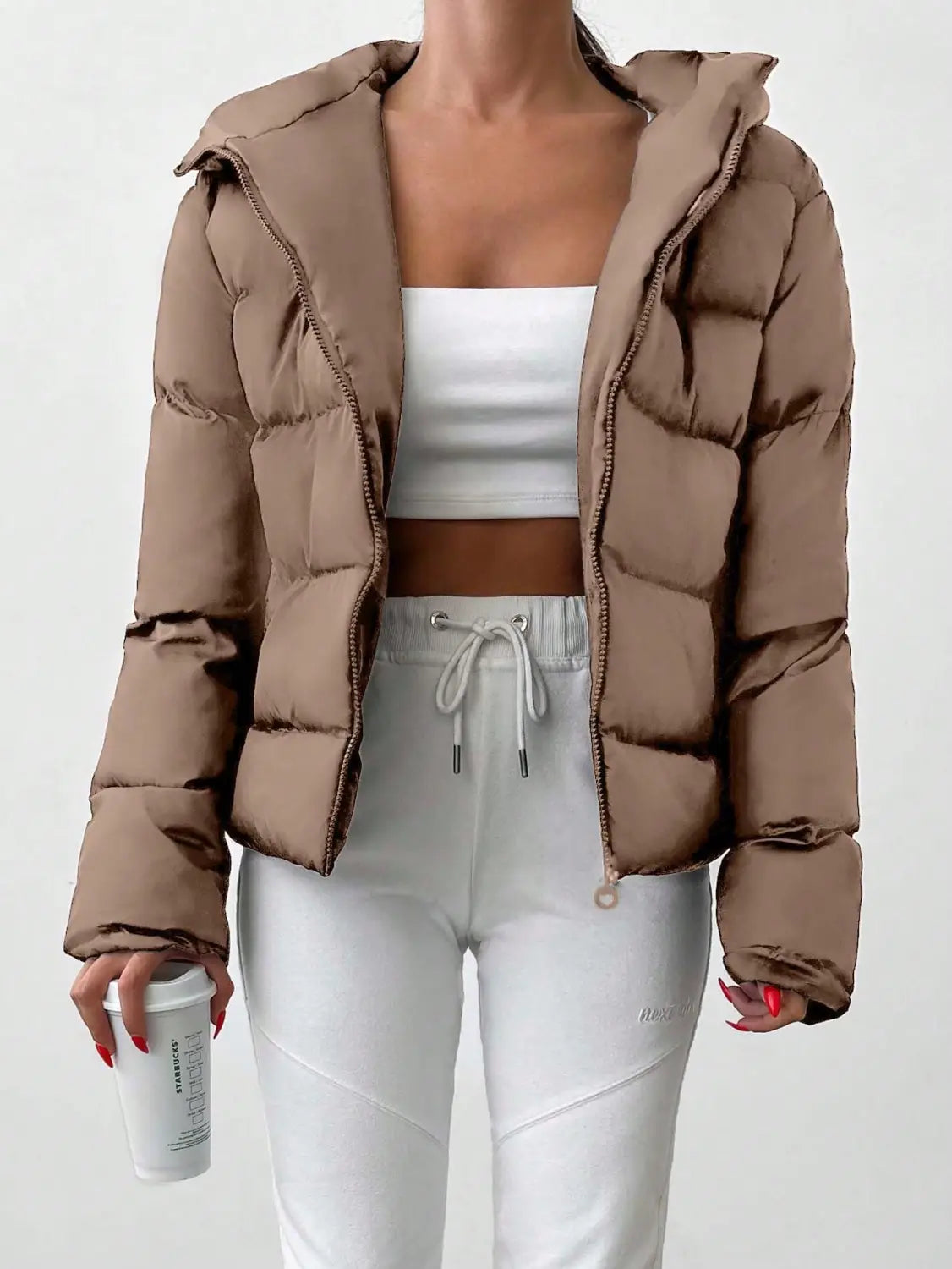 A cozy women’s hooded puffer jacket in tan with quilted design and warm insulated material.
