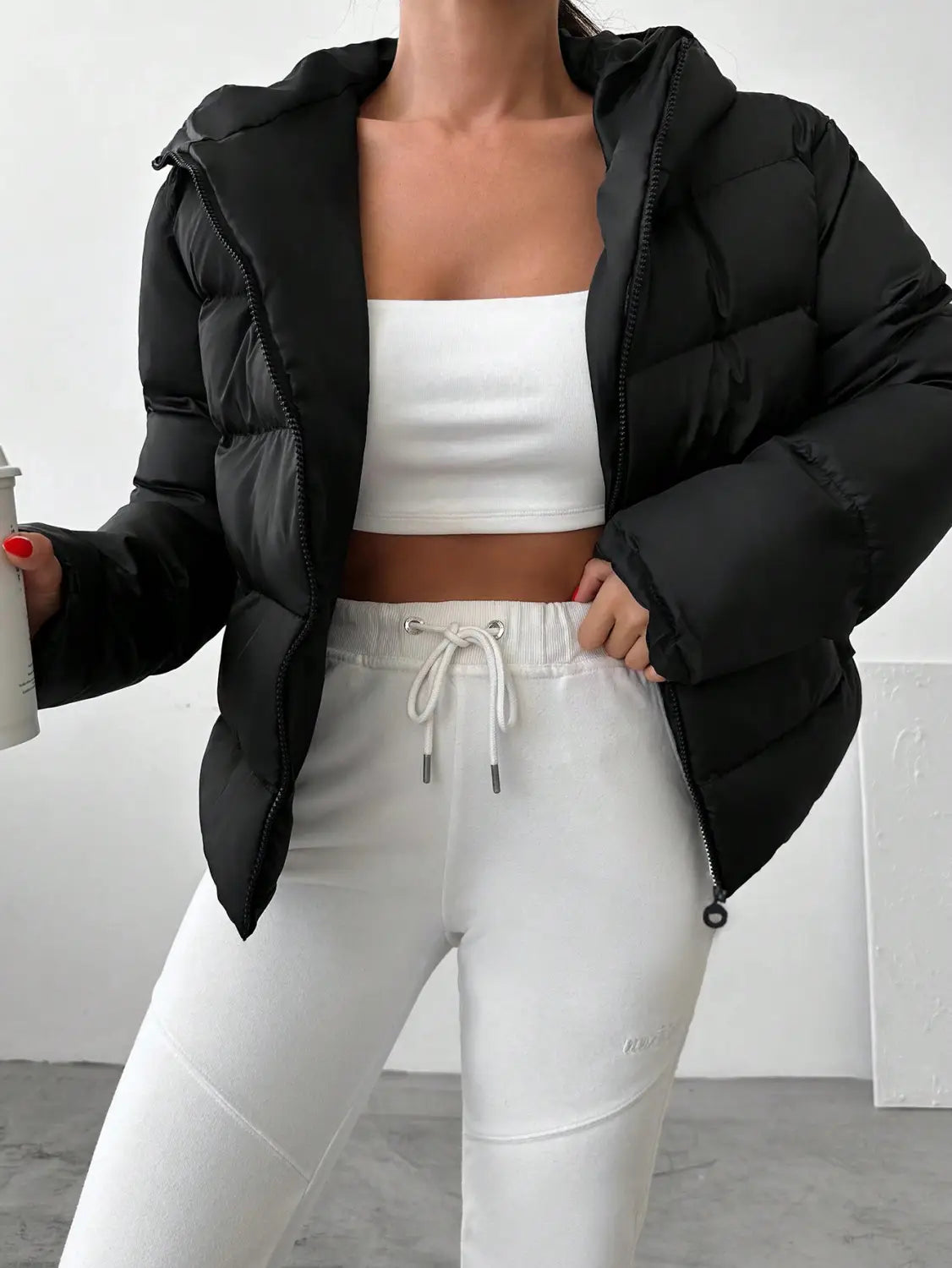 Women’s hooded black puffer jacket with quilted design and insulated material for cold weather.