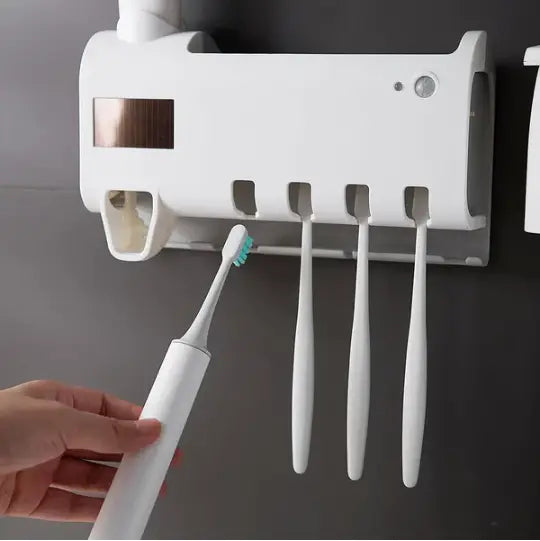 a white electric toothbrush with light blue bristles placed in a uv sterilizer toothbrush holder and dispenser designed for hygienic oral care storage