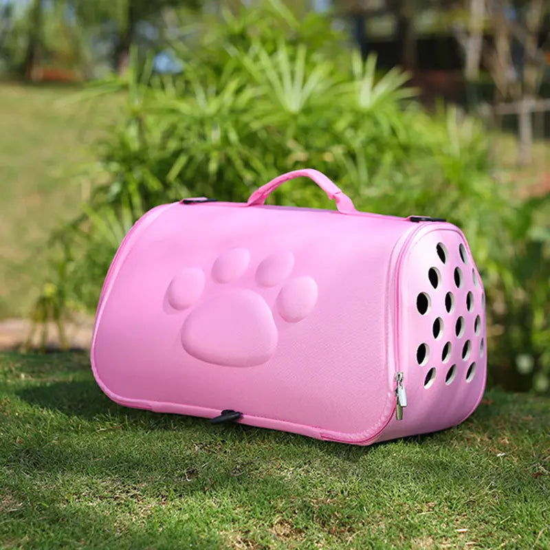 Eva folding pet carrier bag in pink featuring a raised paw print design and circular ventilation holes for secure and breathable transport.