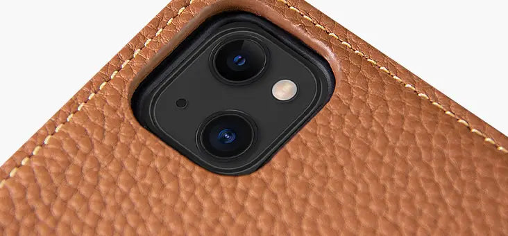 Back side of a tan leather wallet case for iPhone 16 15 14 13 12 11 with textured grain, contrasting light brown stitching, and a black camera module housing for iPhone 13.