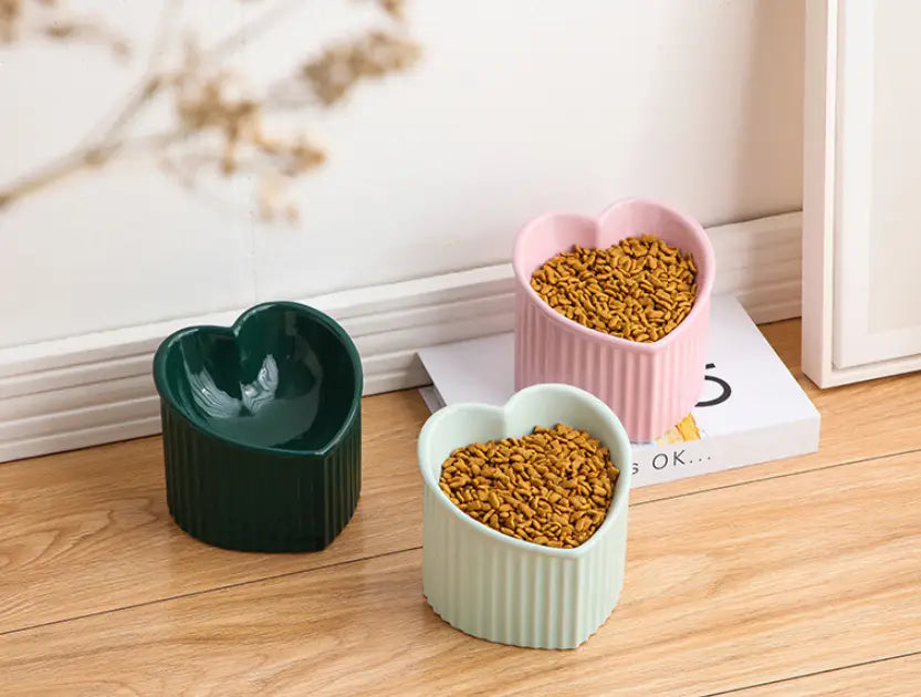 Three heart-shaped ceramic pet food bowls in green pink and mint with vertical ridges from the tilted ceramic cat bowl set 4 pack.