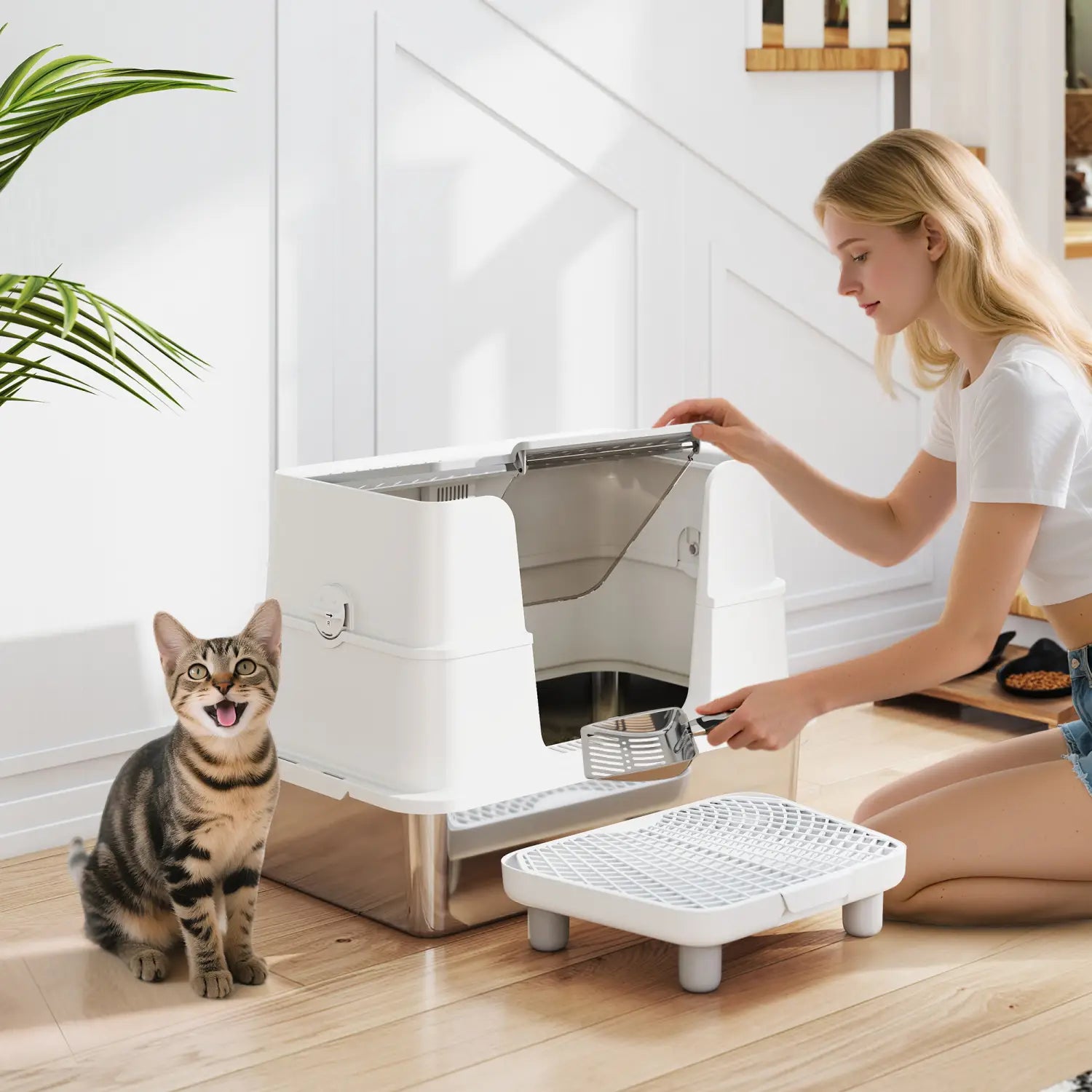 White and stainless steel stainless steel XL enclosed cat litter box with a transparent lid and integrated scoop tray featuring a self-cleaning mechanism.