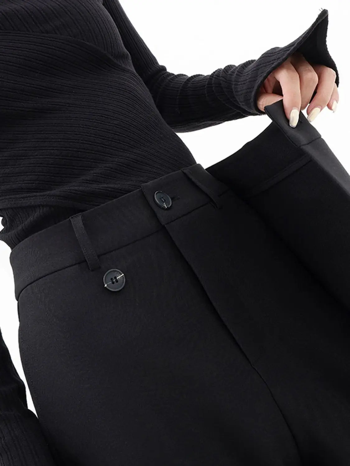 Schwarze asymmetrische Weitbein-Hosen mit hoher Taille, figurbetonter Passform und zwei vorderen Knöpfen.