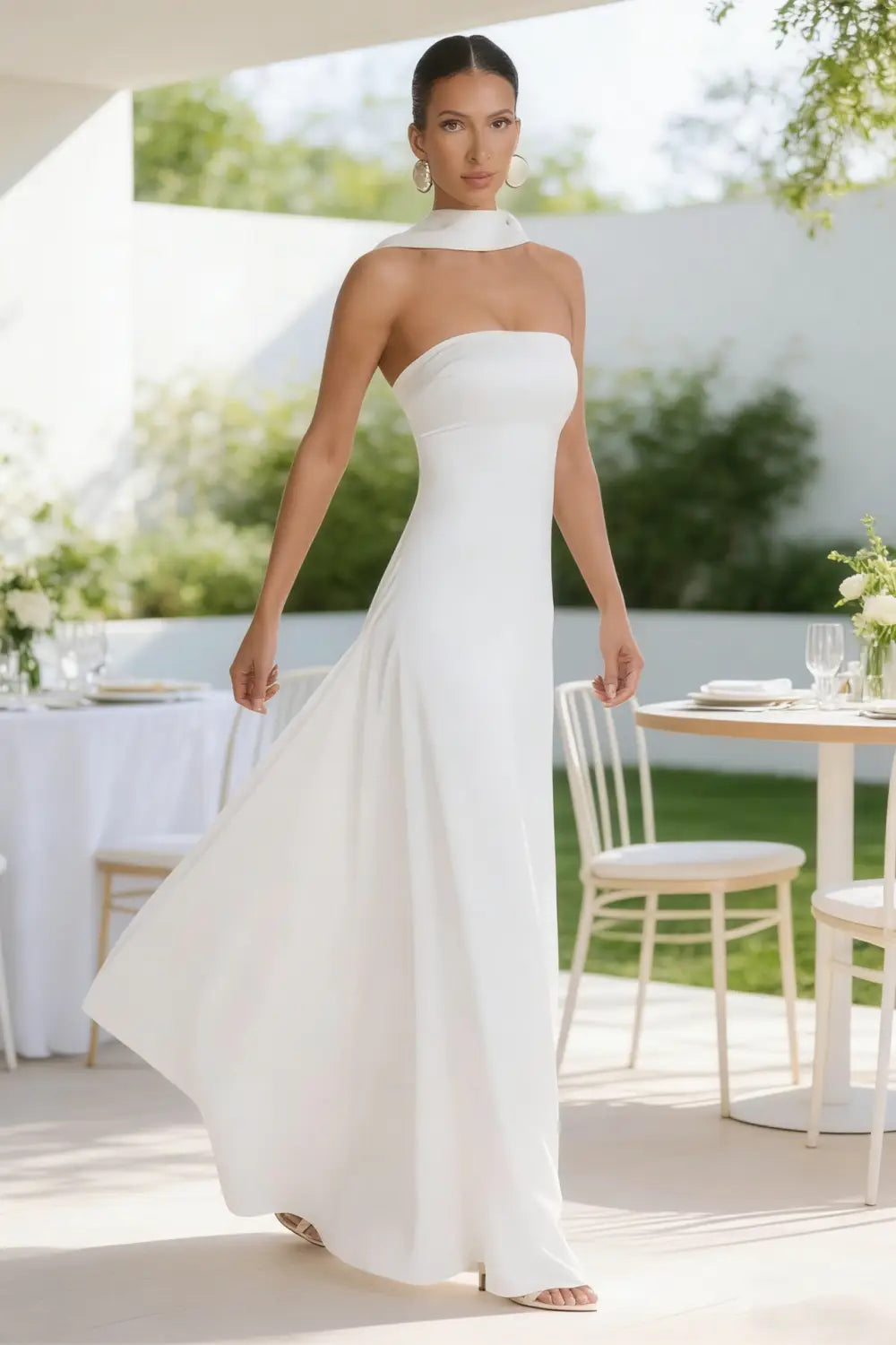 Un elegante vestido de noche sin tirantes de satén blanco, con detalle drapeado en el hombro y falda fluida.
