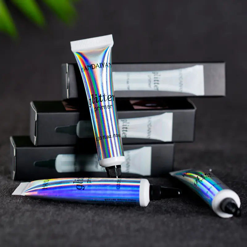 Leche de sombra de ojos iridiscente de base de brillo Handaiyan en un tubo iridiscente holográfico con tapa negra y boquilla blanca para la aplicación de maquillaje