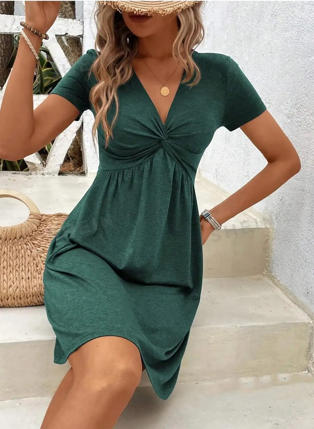 A deep green twist front v neck short sleeve midi dress featuring a knotted front detail.