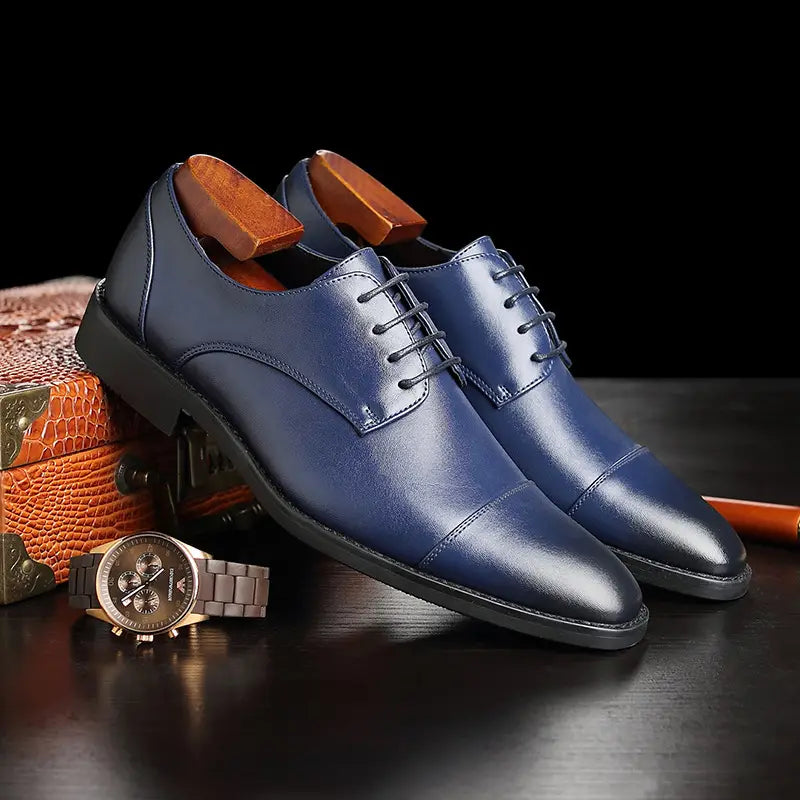 Herren-Businessschuhe im britischen Stil mit spitz zulaufender Zehenpartie aus Kunstleder in tiefem Blau, mit polierter Oberfläche und kontrastierenden schwarzen Gummisohlen.