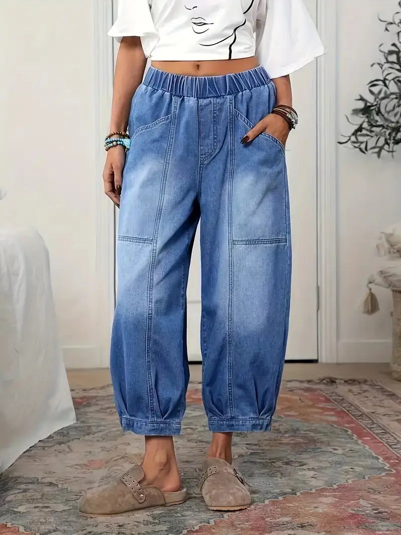 Pantalon capri en denim bleu clair à taille haute et ceinture élastique, avec des jambes resserrées dans une coupe décontractée.