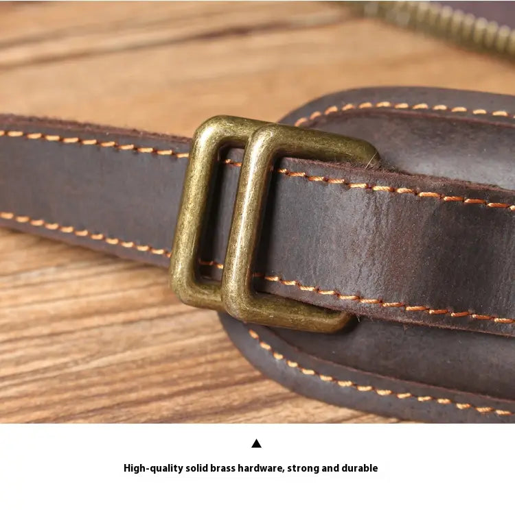 Dark brown cowhide leather strap with contrasting tan stitching and vintage brass buckle on men’s vintage leather backpack.