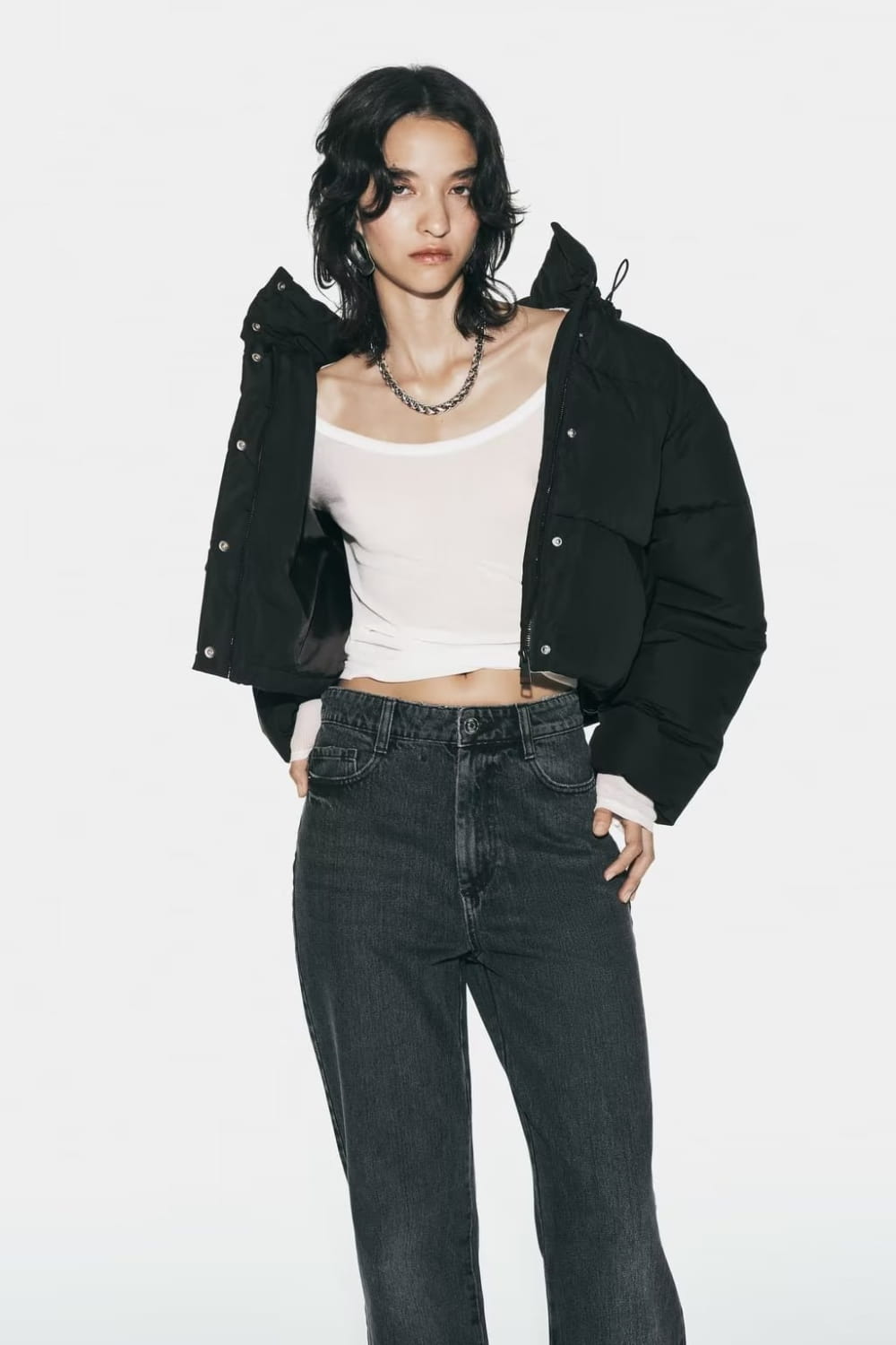 Black quilted hooded puffer coat featuring a black puffer jacket style with a hood and front button closure.
