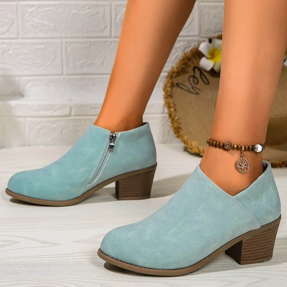 Light blue suede ankle boots with a chunky brown heel and side zipper for stylish and comfortable wear.