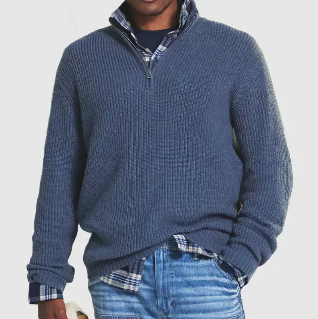 Pull en maille à col montant zippé au quart pour hommes, en maille côtelée bleue, avec le col d’une chemise à carreaux laissé apparent.