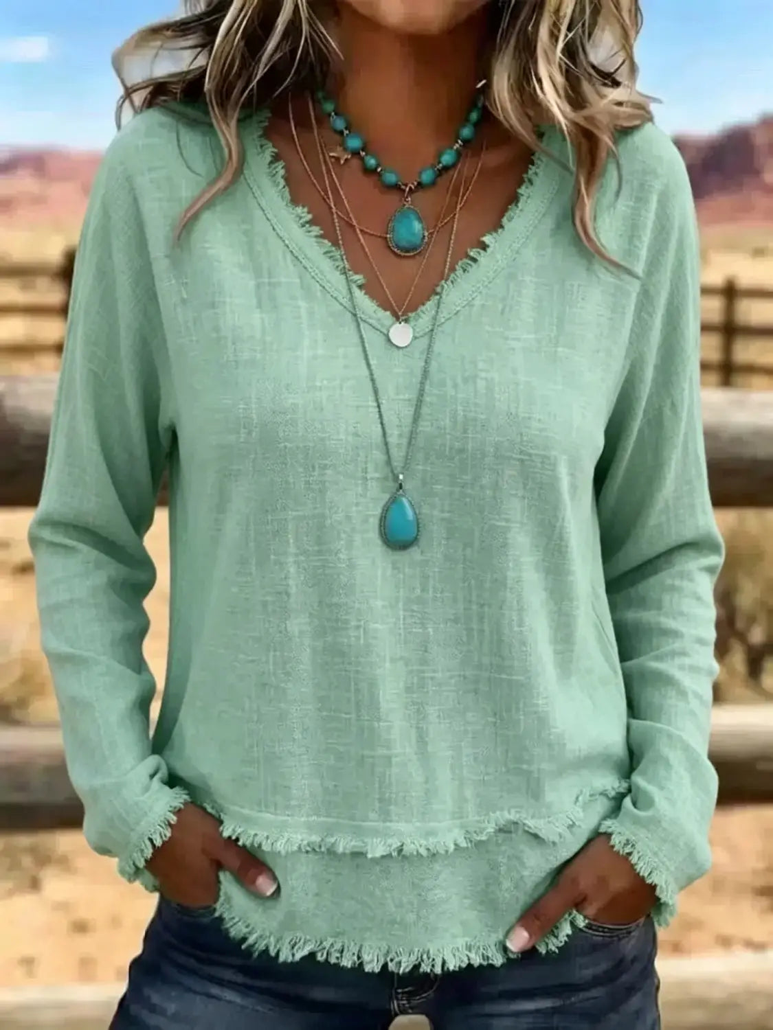 T-shirt à manches longues pour femmes vert clair à encolure en V, avec ourlet effiloché, réalisé dans un tissu doux pour un usage décontracté.