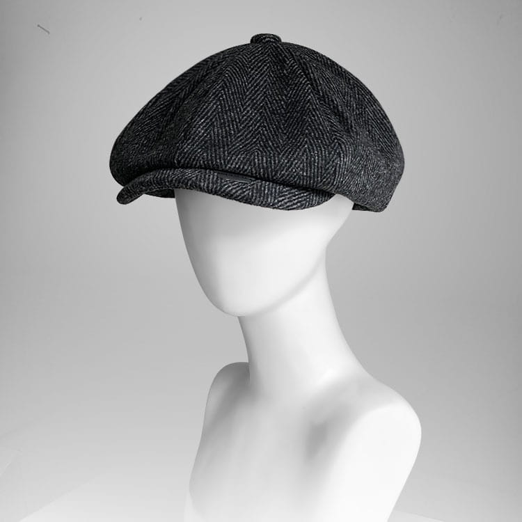 A dark gray herringbone woolen octagonal flat cap featuring a structured eight-panel design and a slightly curved brim.