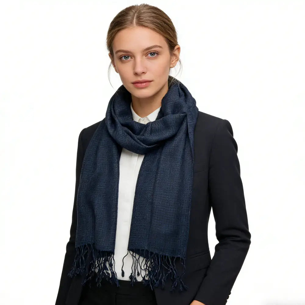Une écharpe en sergé jacquard à chevrons marine, en mélange de laine, dotée d’un tissage discrètement texturé et de bords frangés.