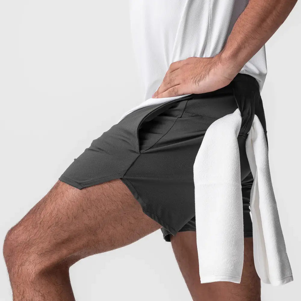 Men quick dry athletic sports shorts in dark gray with a white towel draped over the side.