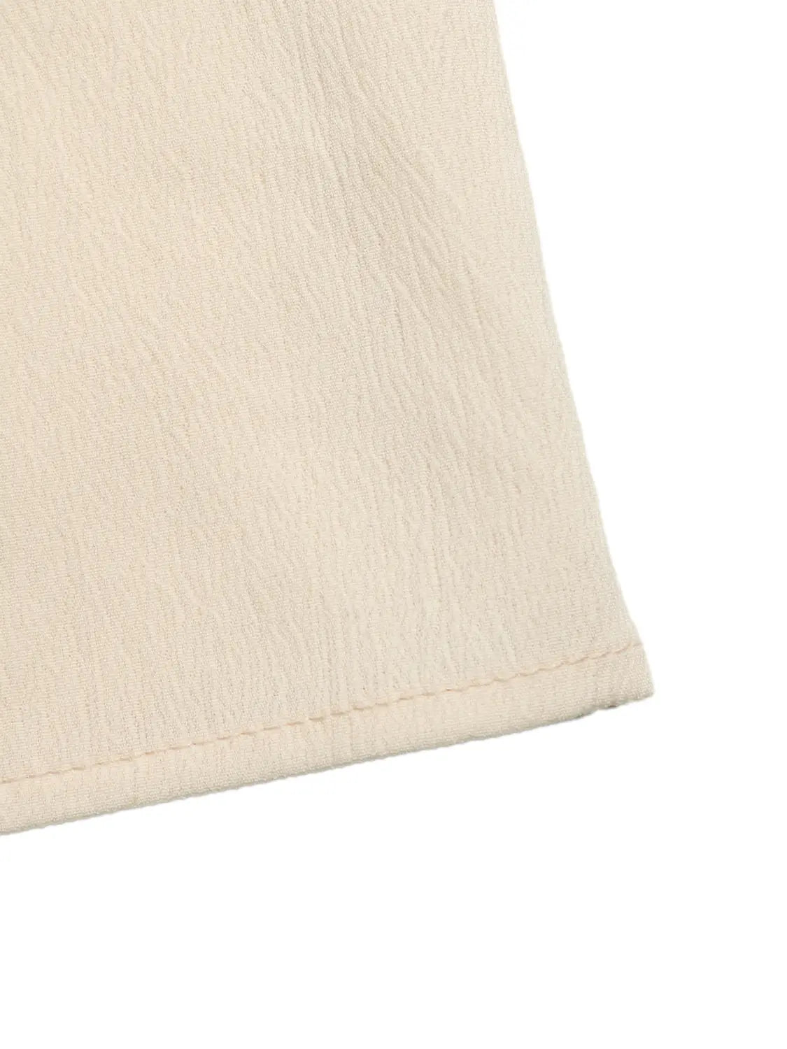 Cream strapless pleated jumpsuit featuring cream-colored fabric with a subtle textured weave and a neatly stitched hem.