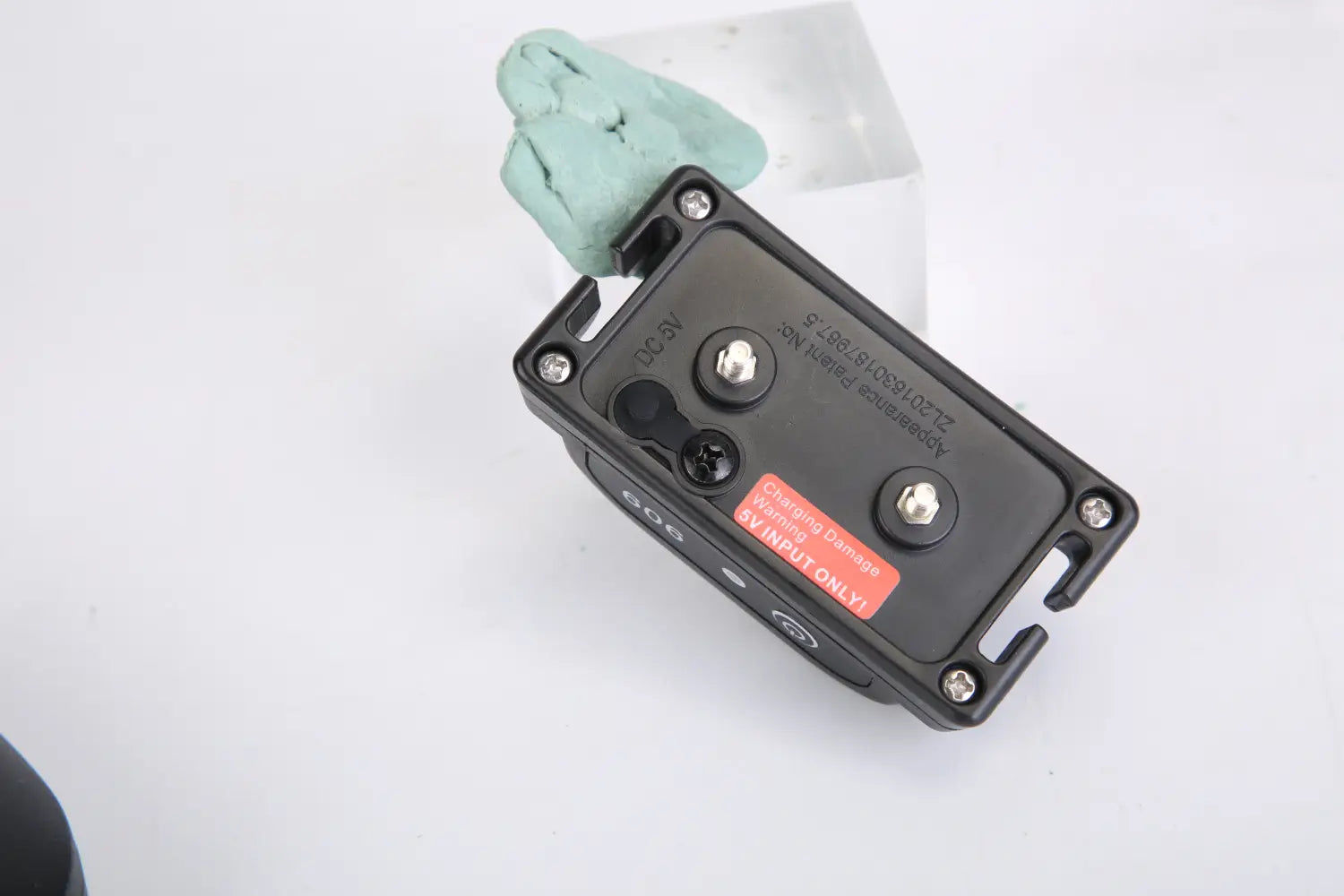 système de clôture sans fil pour chien rectangulaire noir avec moniteur de localisation GPS, collier affichant le dos avec des vis en argent et une étiquette d’avertissement rouge