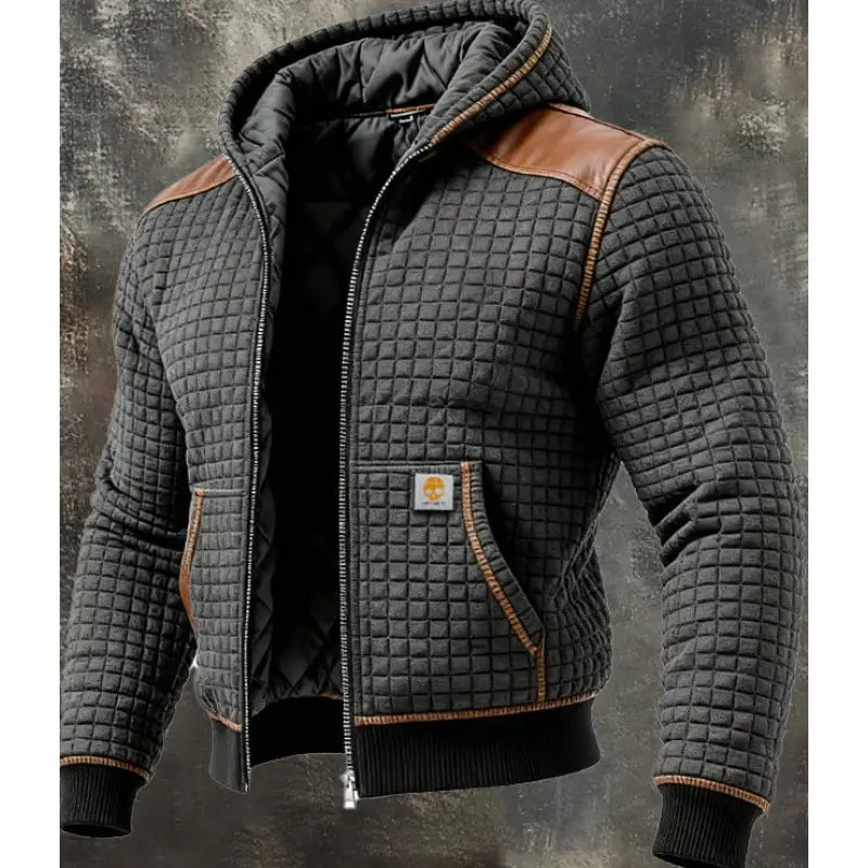 Veste à capuche zippée doublée de polaire pour homme en tissu matelassé noir, panneaux d’épaule en cuir marron et passepoil avec écusson logo Carhartt sur la poitrine.